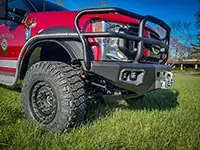 Red fire truck with heavy-duty Founders tires and grille guard