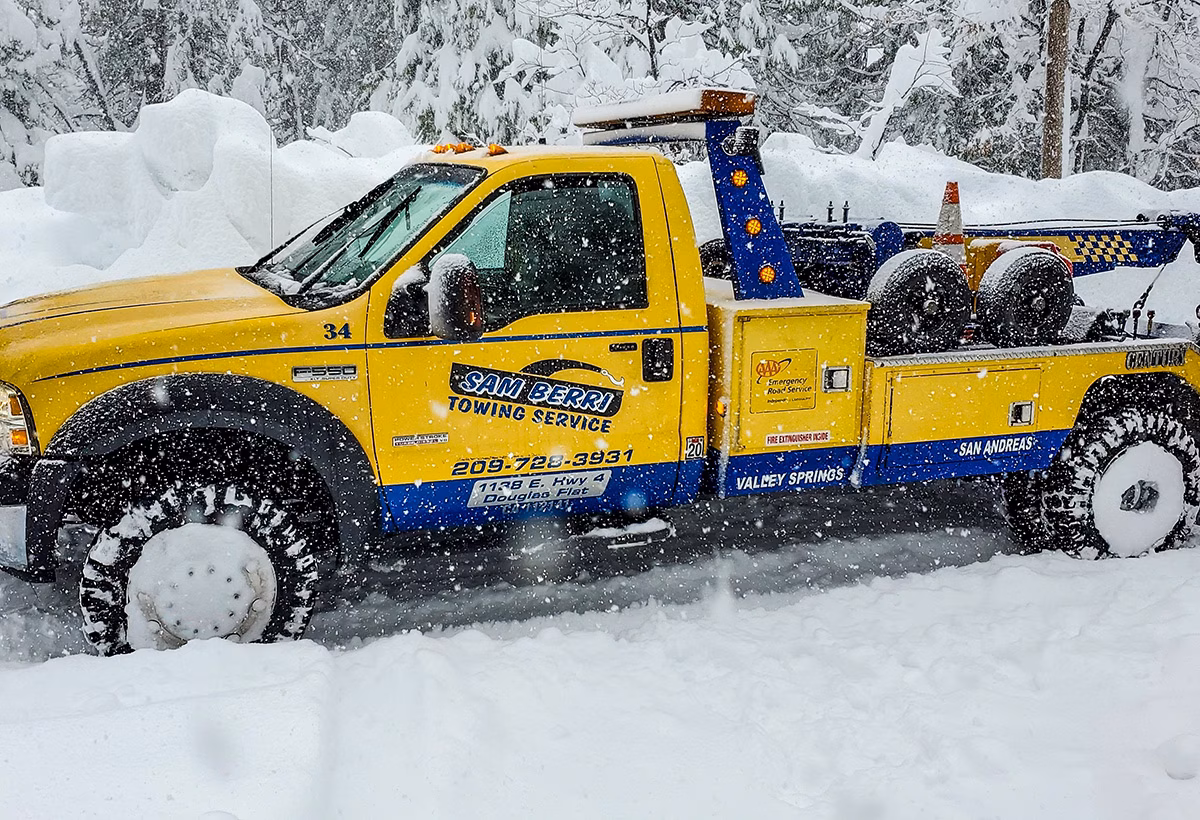 Yellow tow truck in heavy snow